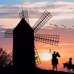 Don Quijote and Sancho Panza at the windmills in sunset